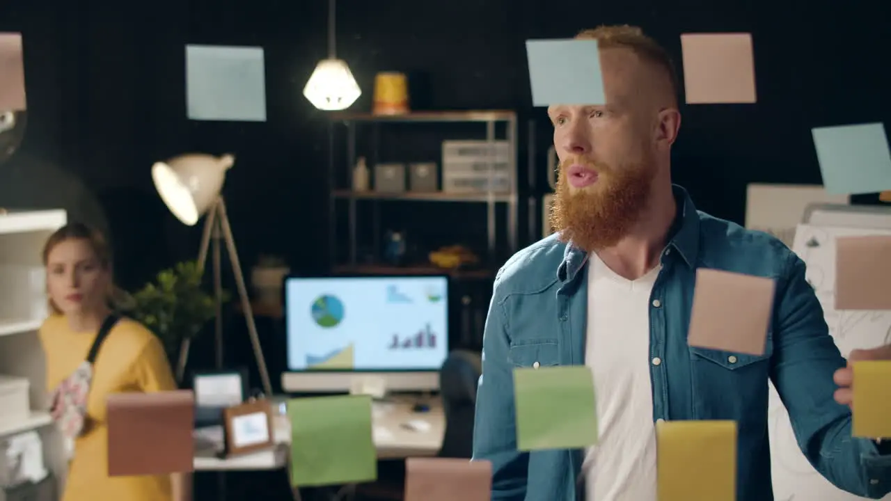 Puzzled guy asking female colleague for advice in business hipster office