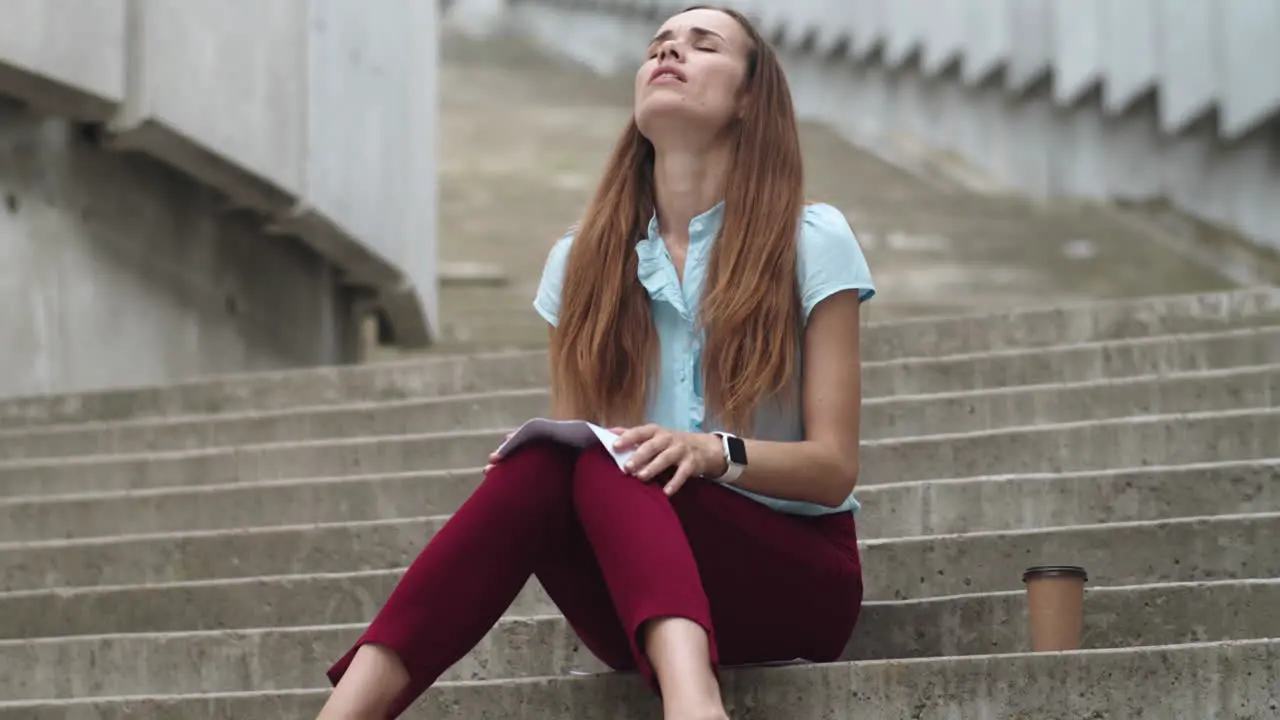 Businesswoman sitting on stairs with papers Professional meditating on street