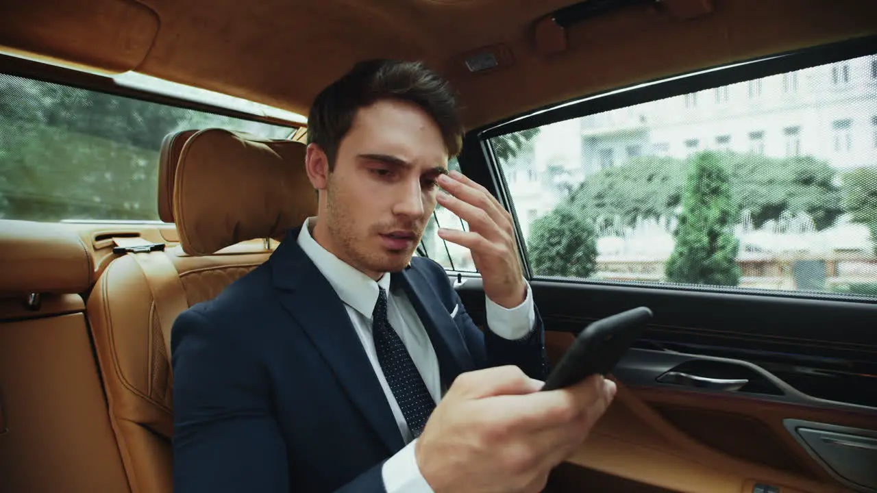 Portrait of upset business man getting bad news with smartphone in business car