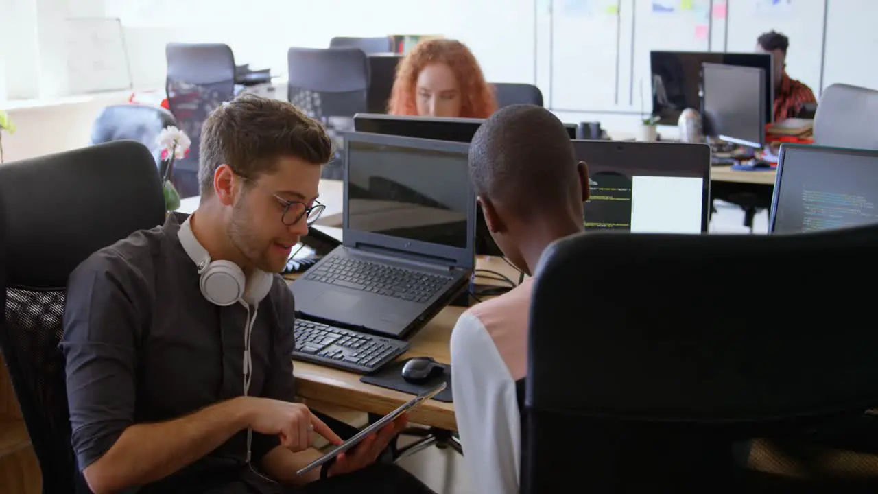 Side view of young cool mixed-race business team planning and sitting at desk in a modern office 4k