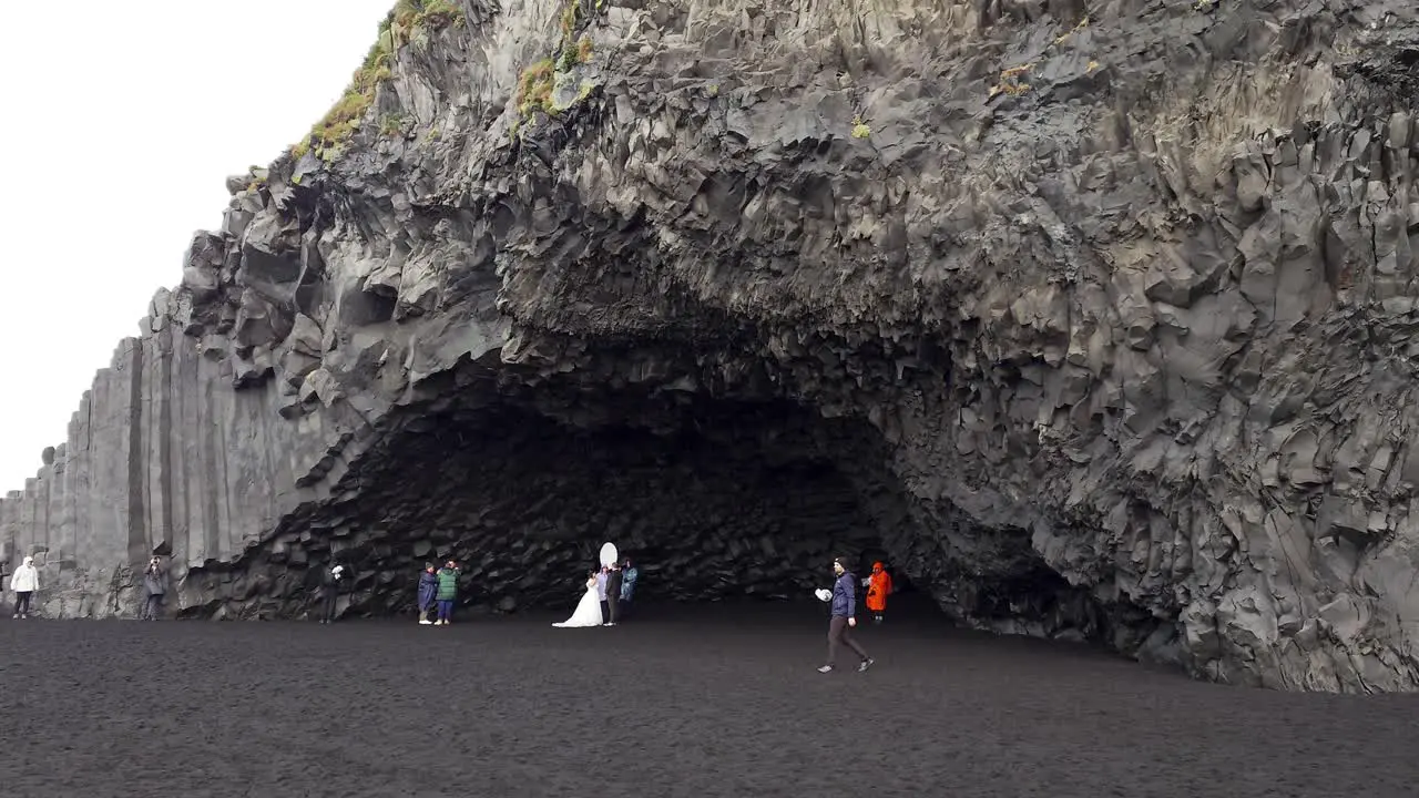 Photoshoot of married couple at Reynisfjara Black Sand Beach on a rainy day in Iceland Wide angle