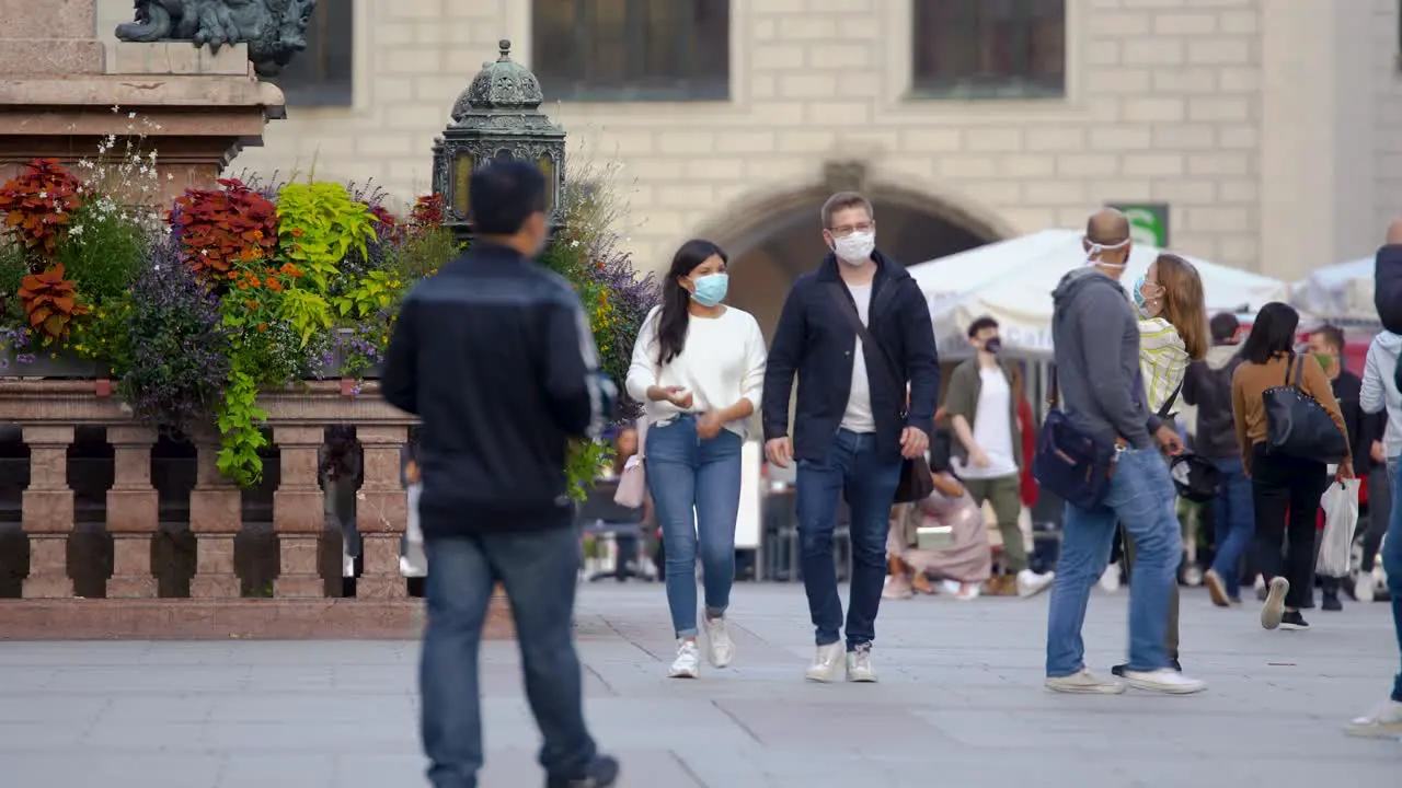 A couple walks with face masks to protect themselves from the coronavirus in downtown munich