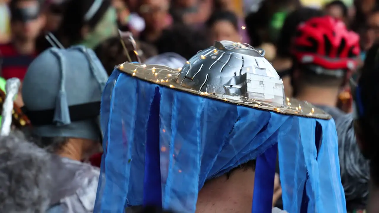 People celebrating by dancing on the street during brazilian carnival wearing funny caps on the head