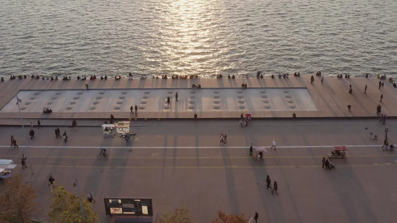 Aerial People passing by in Thessaloniki seaside walkway at sunset