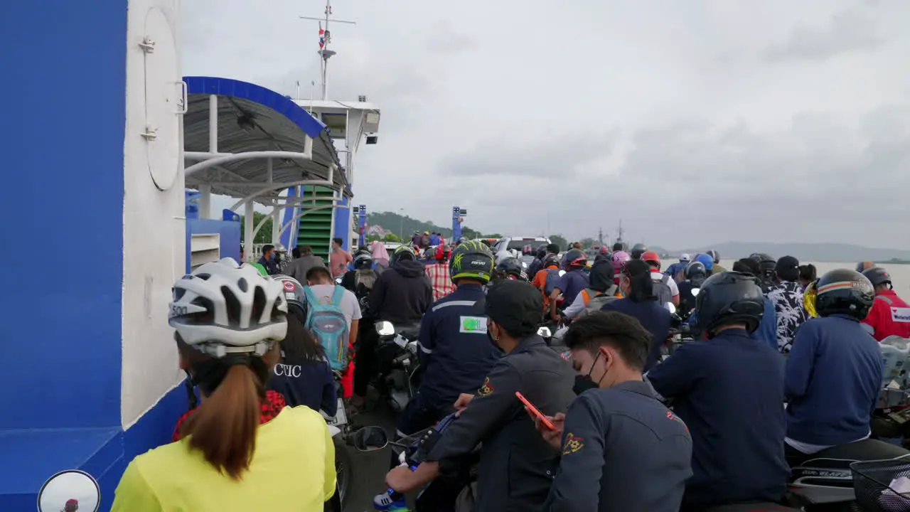 People on motorcycles and bicycles riding on ferry boat Songkhla ferry Thailand