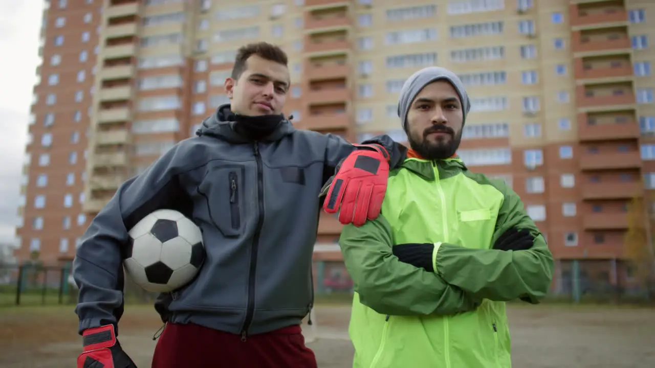 Confident Male Soccer Players Posing And Looking At Camera On The Field