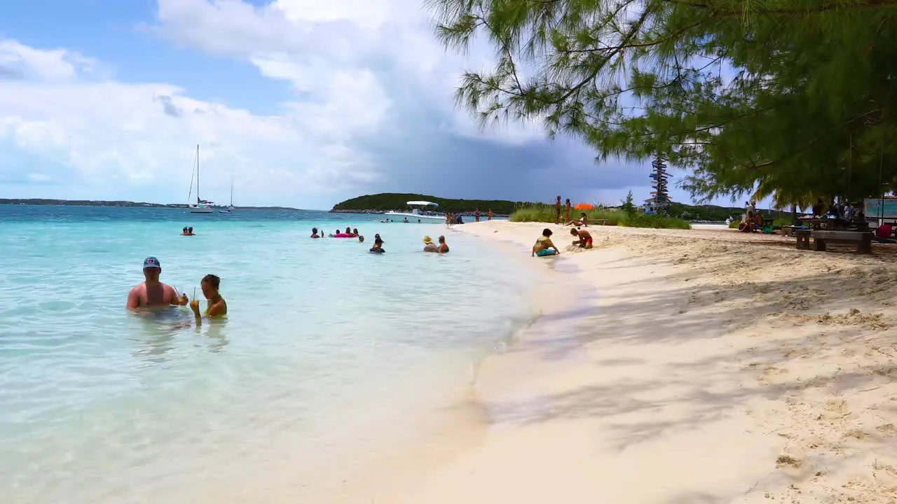 This is a static shot of people relaxing on the famous Chat 'N' Chill beach on Exuma in the Bahamas