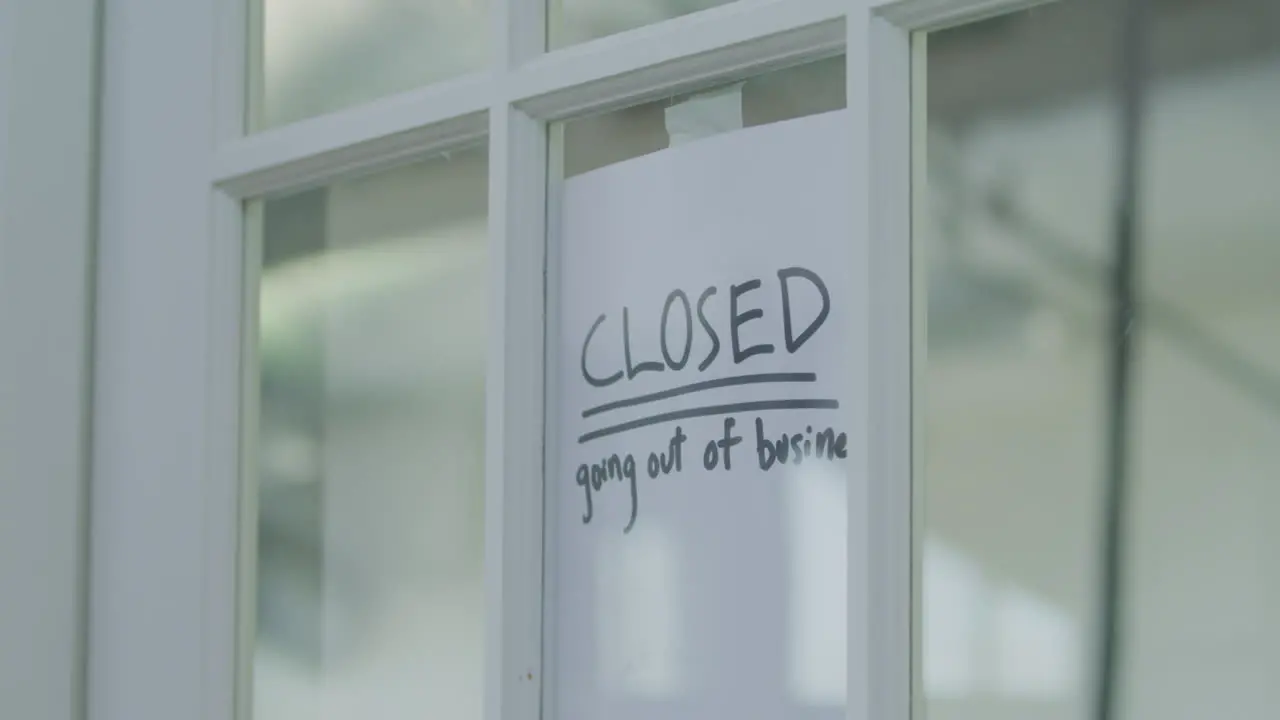 An employee hangs a sign on a window