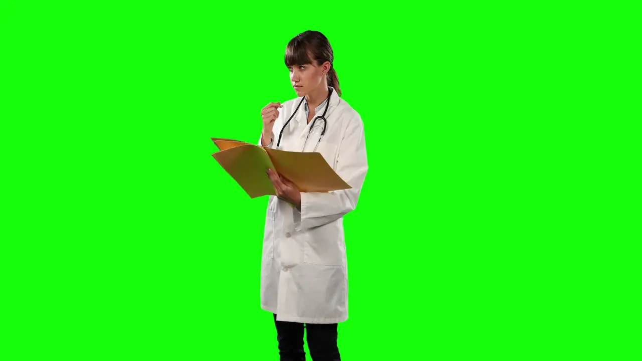 Side view of a doctor checking her papers with green screen