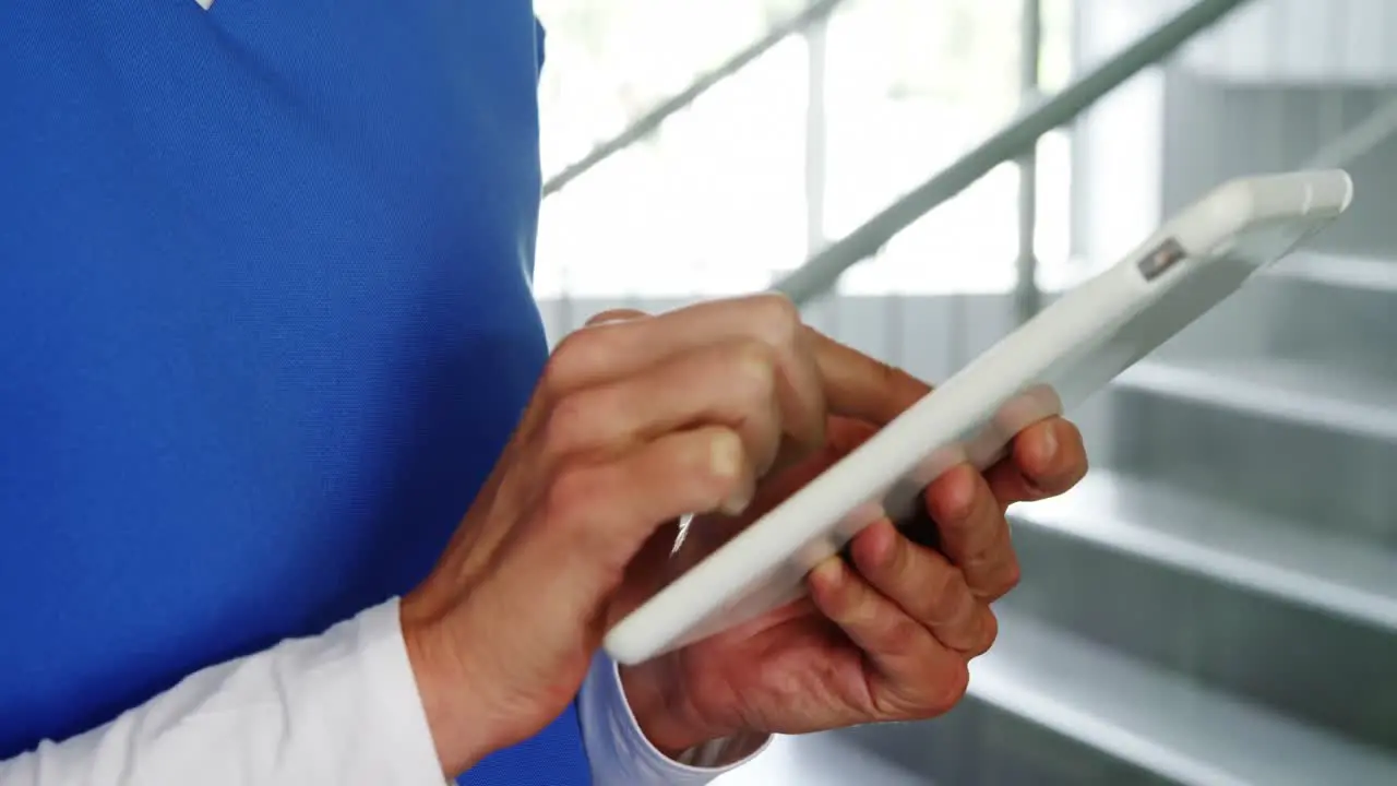 Nurse using digital tablet in corridor