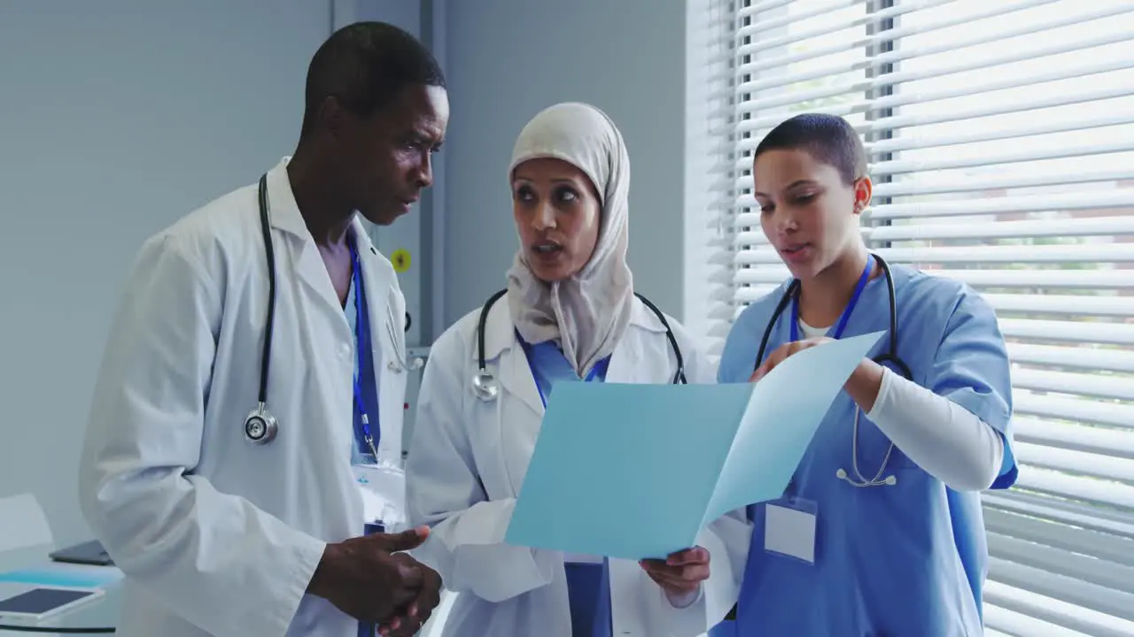 Front view of Multi-Ethnic doctors discussing over medical report in hospital