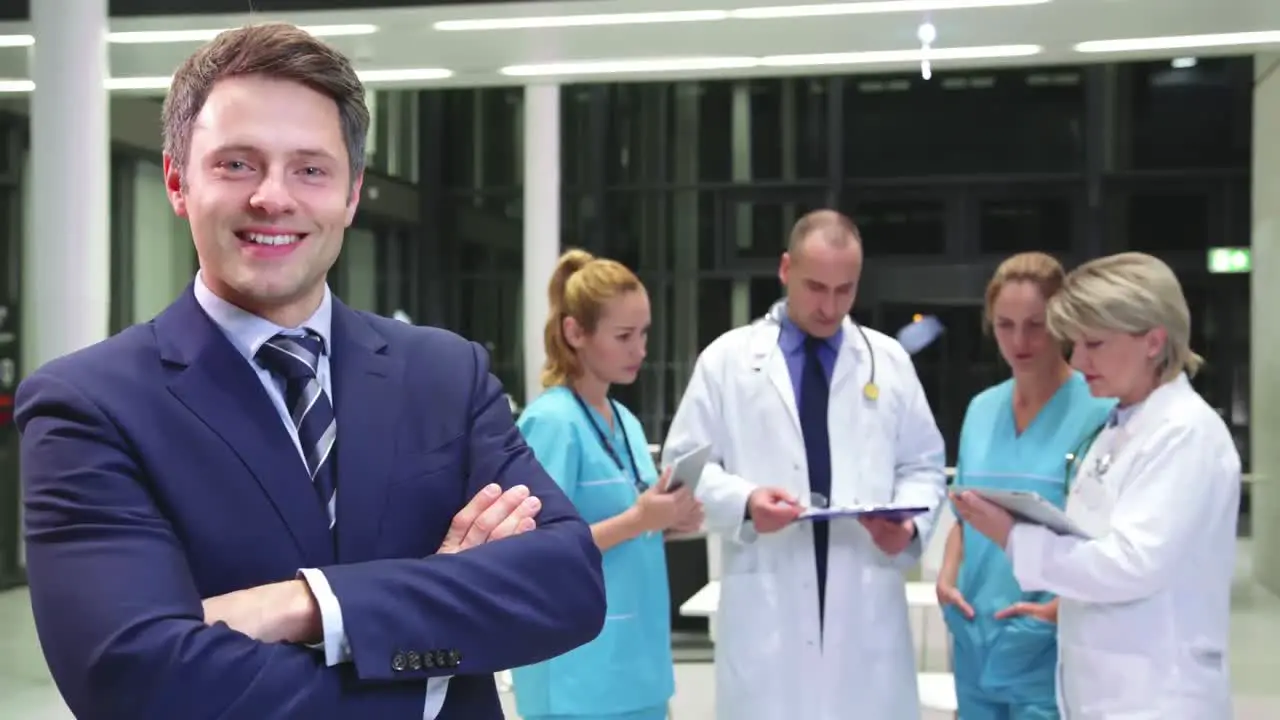 Businessman standing with arms crossed in corridor