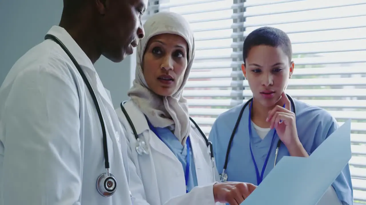 Close-up of Multi-Ethnic doctors discussing over medical report in hospital