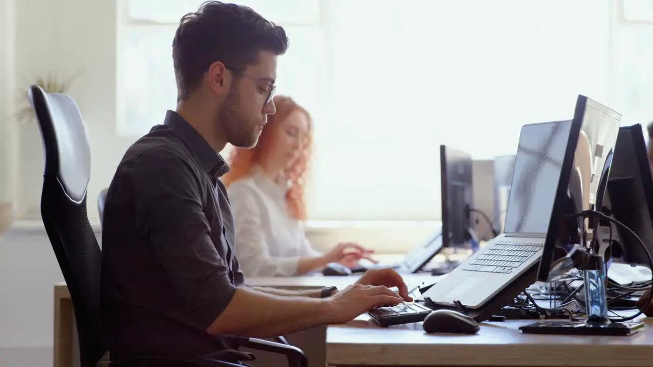 Side view of young cool caucasian business team working at desk in a modern office 4k