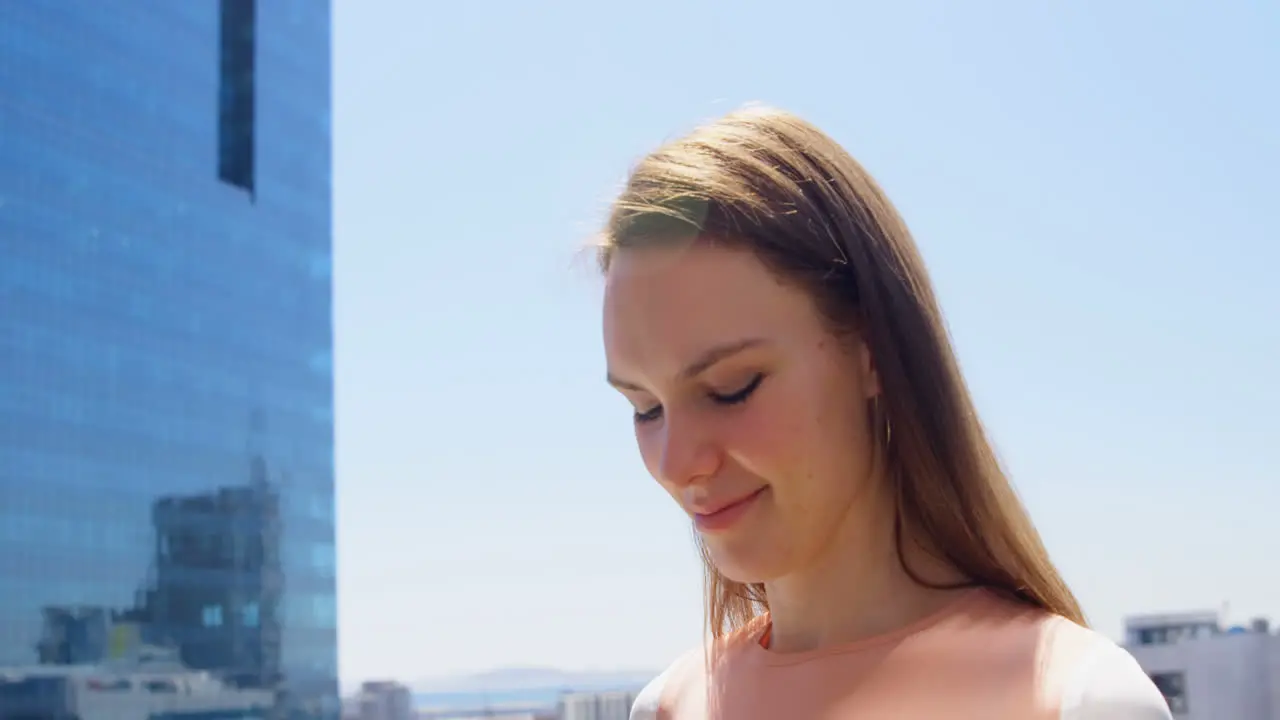 Side view of young caucasian businesswoman looking down and standing in office balcony 4k