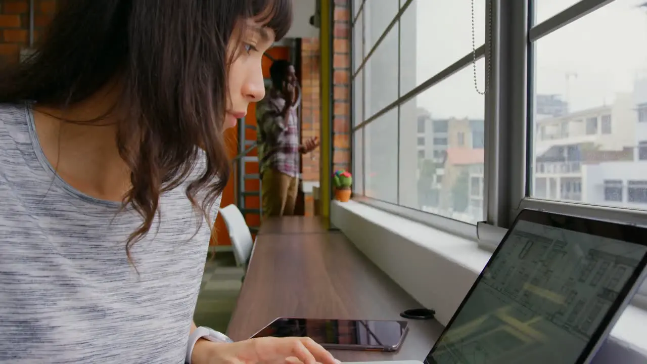 Businesswoman working on laptop in a modern office 4k