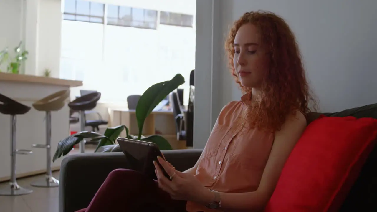 Side view of young caucasian businesswoman working on digital tablet in a modern office 4k