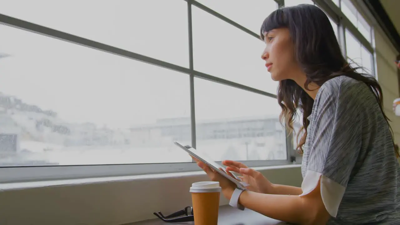 Businesswoman using digital tablet near window in a modern office 4k