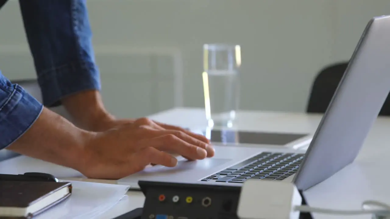 Male executive using laptop in conference room 4k