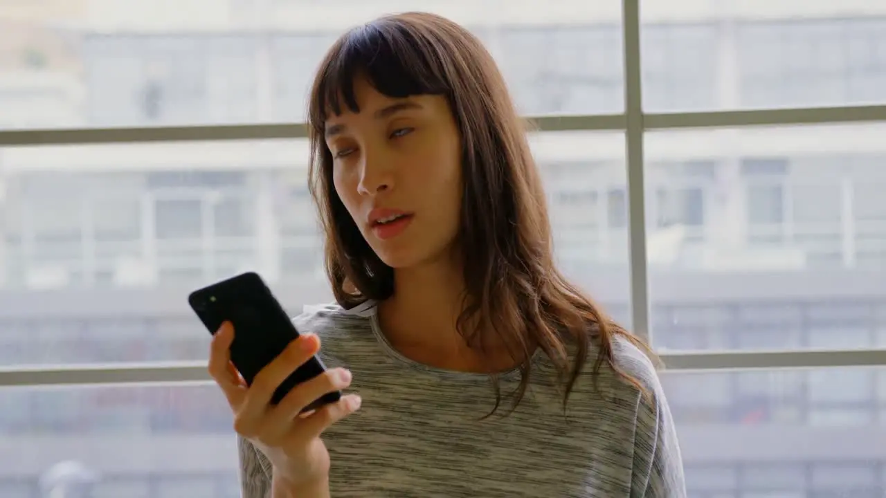 Businesswoman talking on mobile phone in a modern office 4k