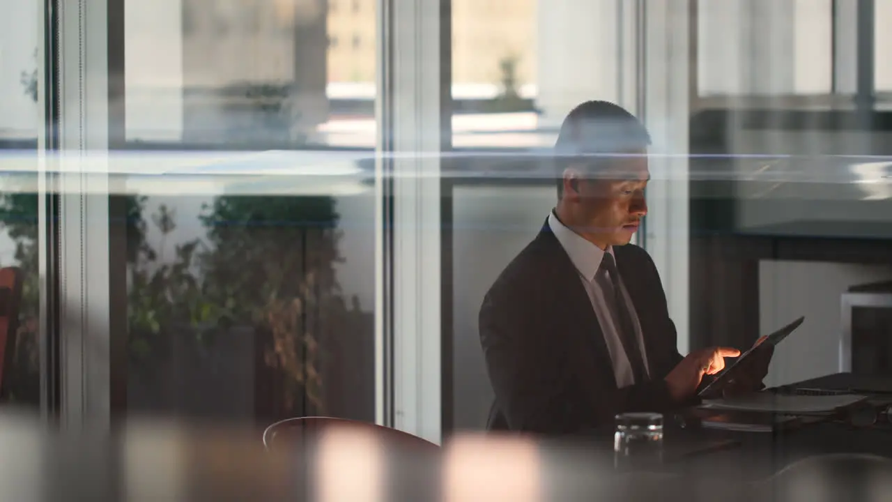 Side view of young Asian Businessman working on digital tablet in the modern hotel 4k