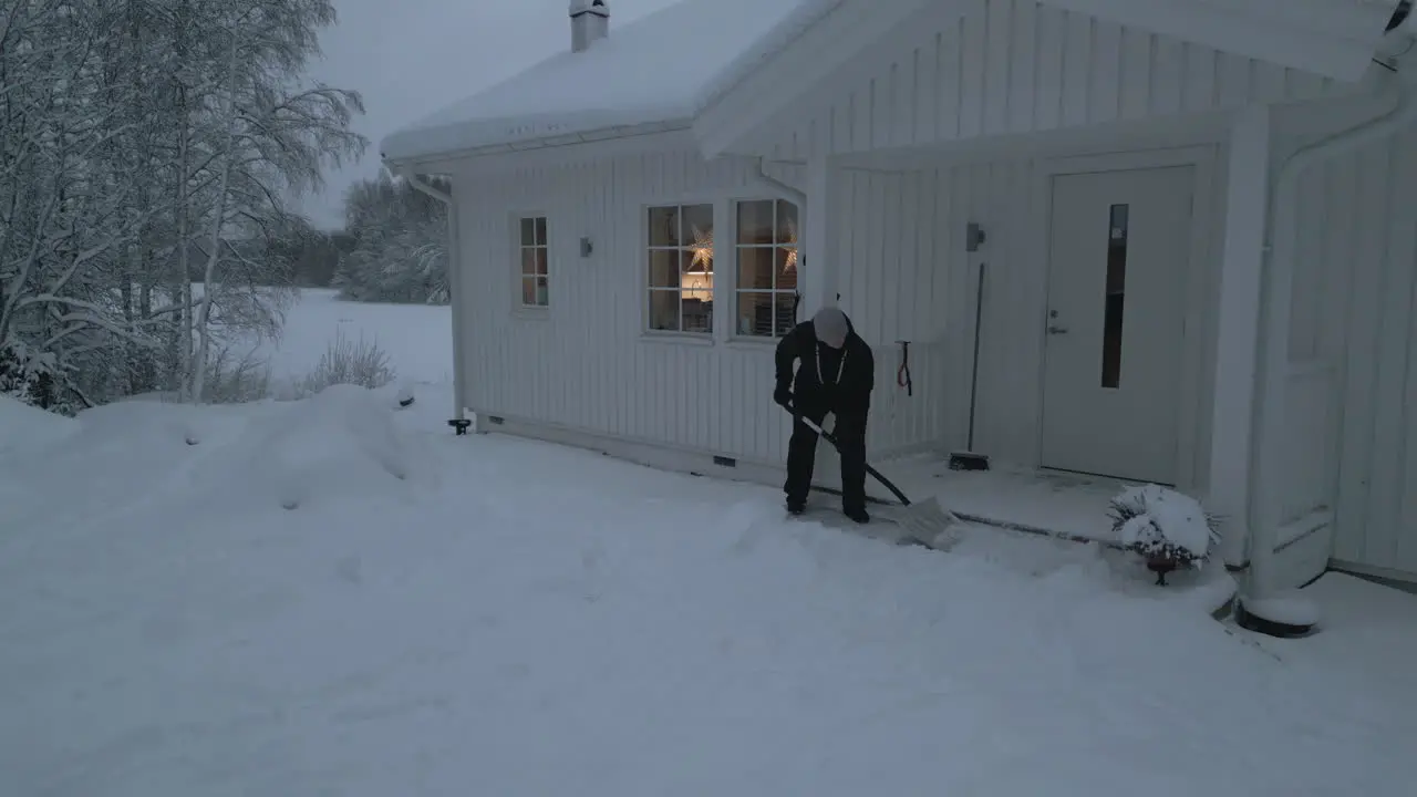 woman shoveling snow in front of her house