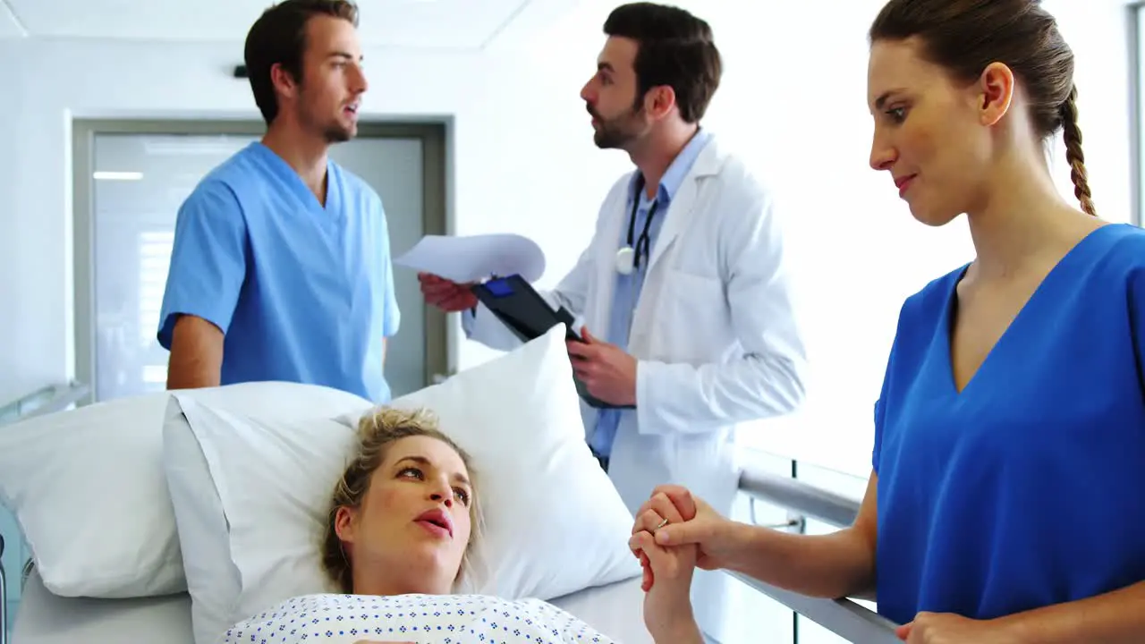 Doctor holding pregnant womans hand