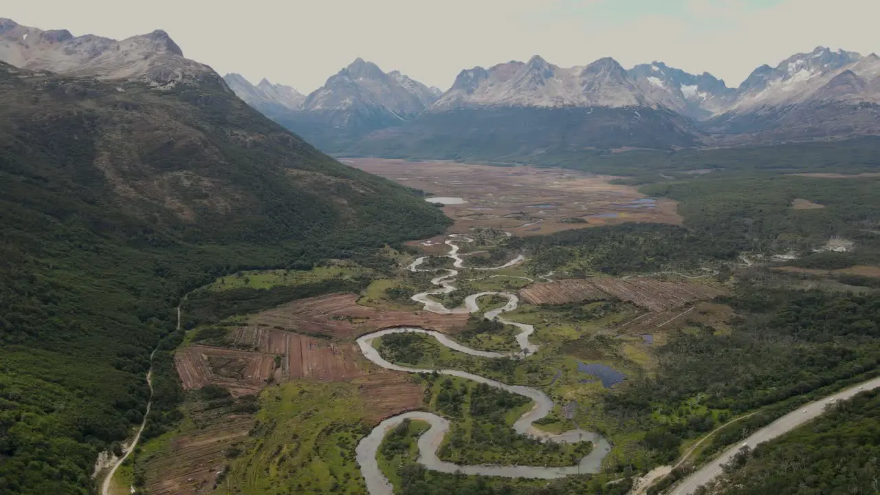 Aerial view of a valley with a river and mountains in the background