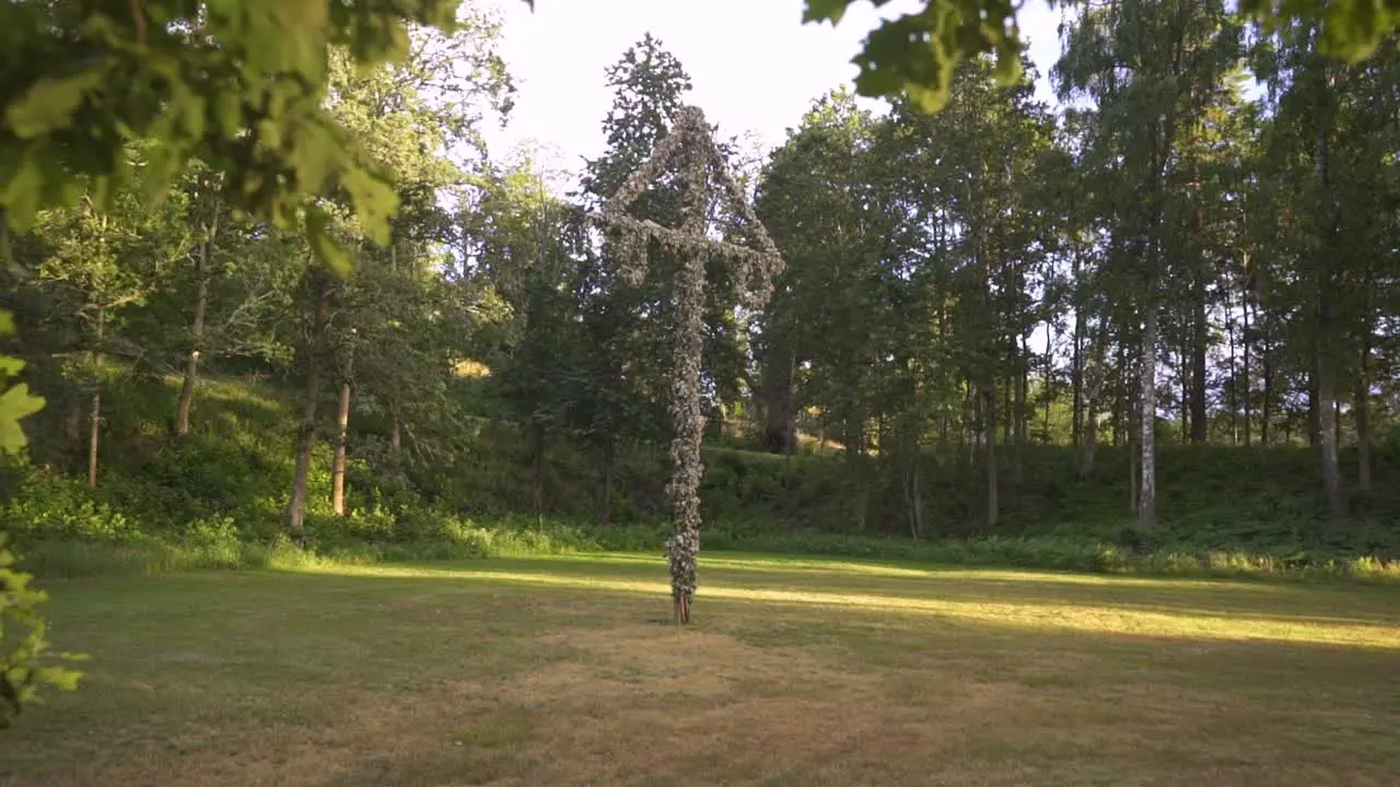 camera glide towards a traditional midsummer pole in sweden in the sunset