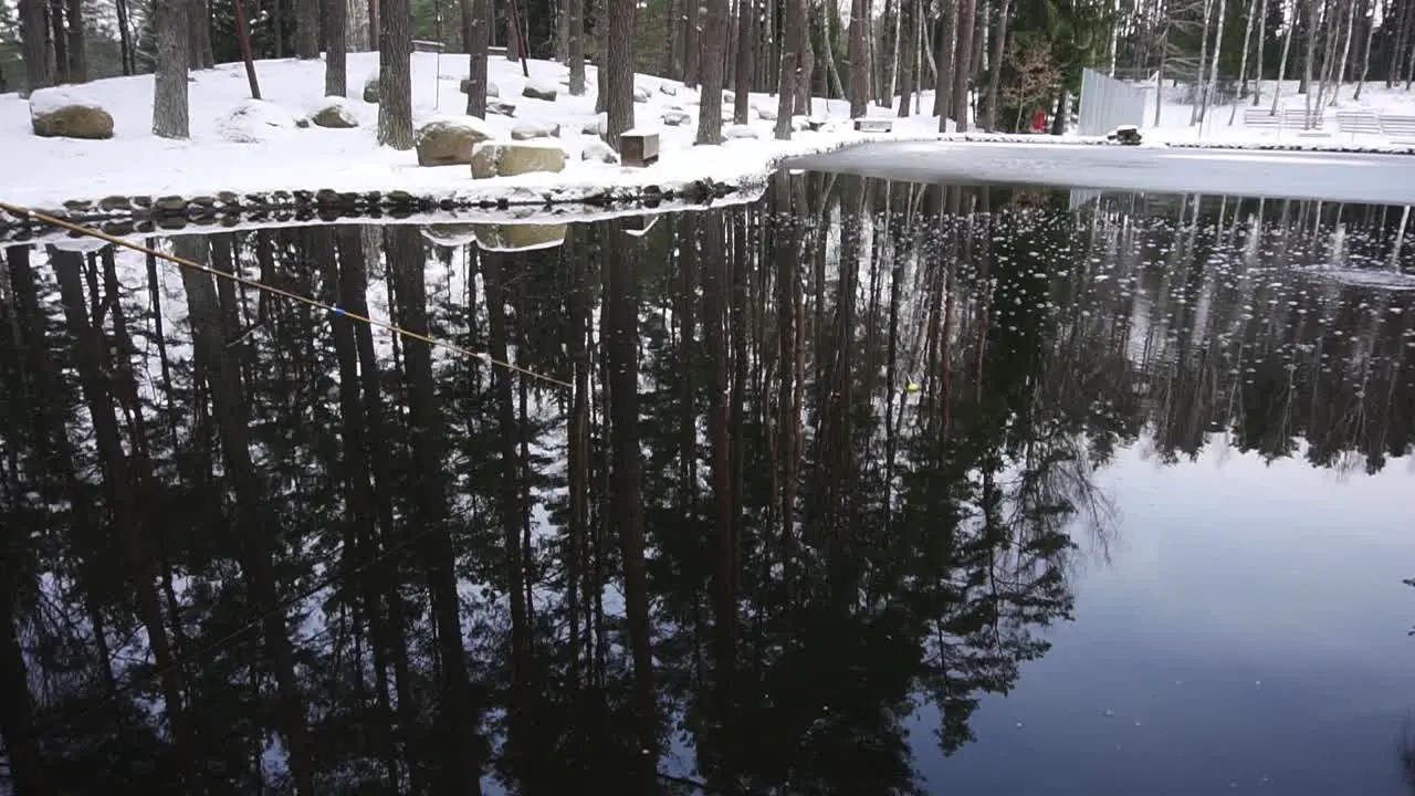 person is fishing in the pond in the snowy winter there is fishing rod in the shot