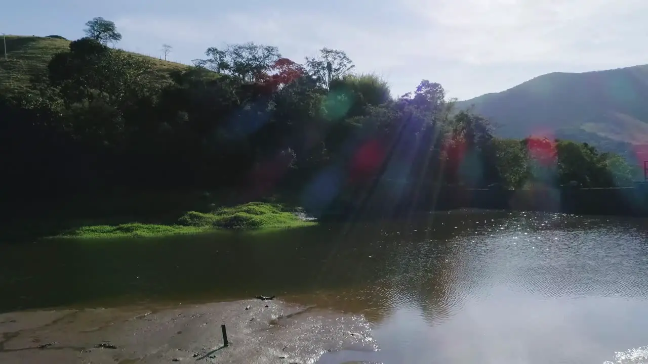 Aerial moving show over lake with sunlights revealing vast atlantic forest valley