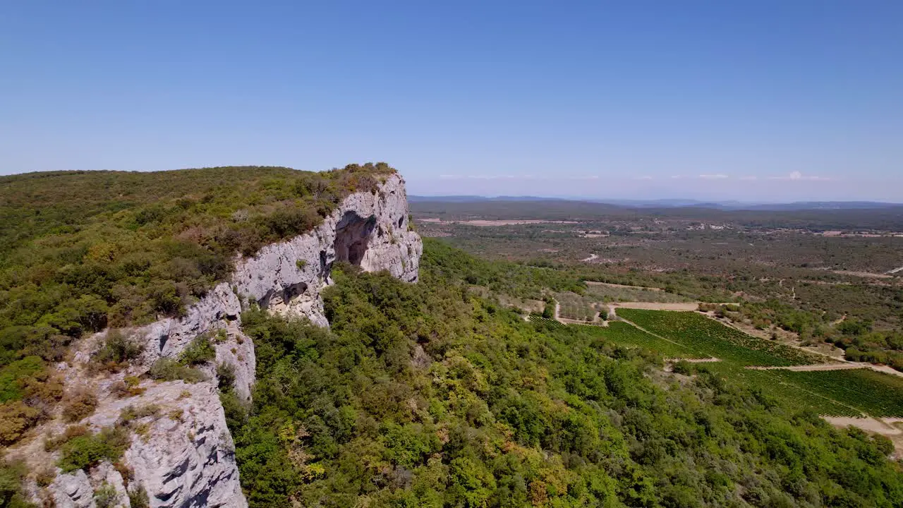 Aerial rotation view of the beautiful nature landscape with cliffs and farmland in Lussan France