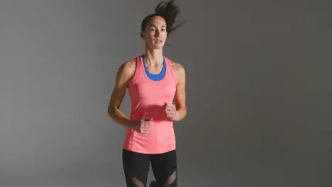 Tracking Shot of Young Woman Jogging and Warming Up at Gym