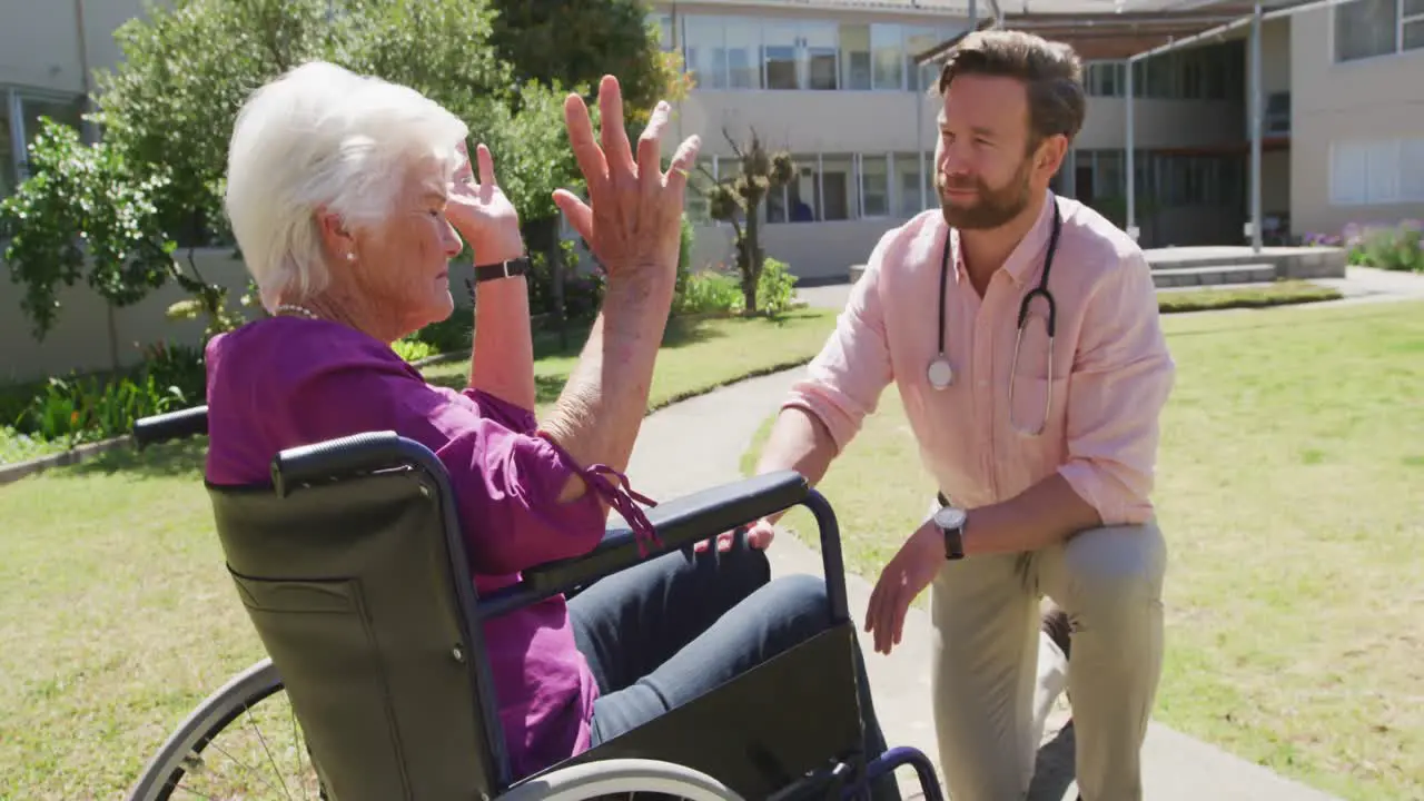 Doctor with a senior woman in the park of a retirement home