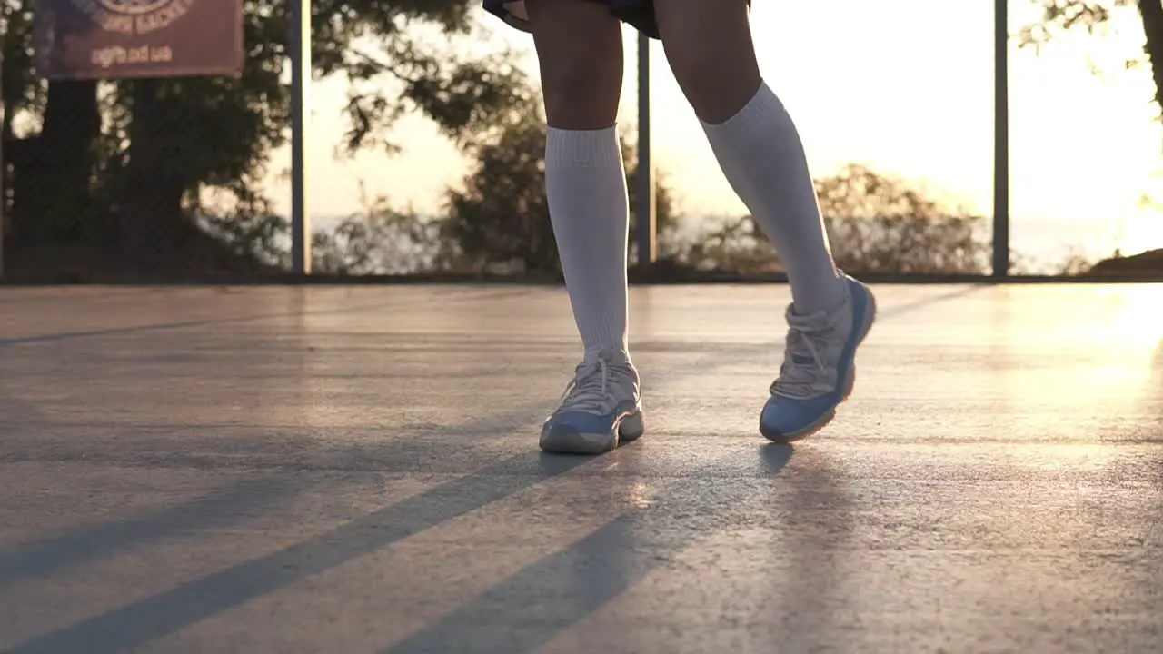 Young Girl Stretching Her Legs In White Sneakers And White Golf Socks On The Local Basketball Court