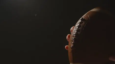 Close Up Studio Shot Of American Football Player Holding Ball With Low Key Lighting 3