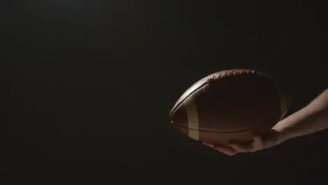 Close Up Studio Shot Of American Football Player Holding Ball With Low Key Lighting 5