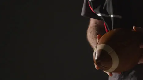 Close Up Studio Shot Of American Football Player Holding Ball With Low Key Lighting 1