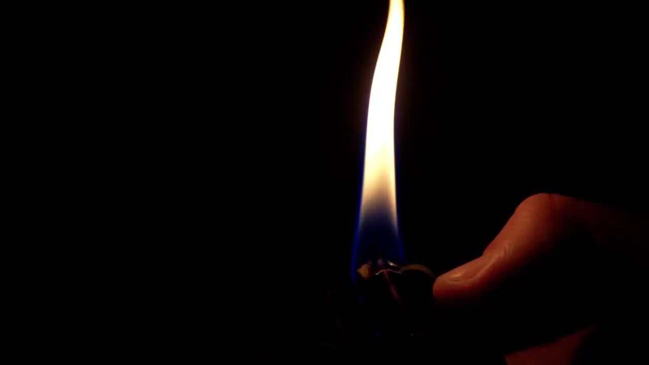 Insert of a hand flicking a lighter in slow motion at 60fps