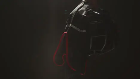 Close Up Studio Shot Of American Football Player Holding Helmet And Team Jersey With Low Key Lighting 