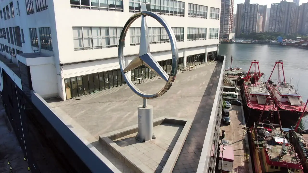 Mercedes Benz sign spinning on top of Hong Kong Mercedes Benz main showroom Aerial view