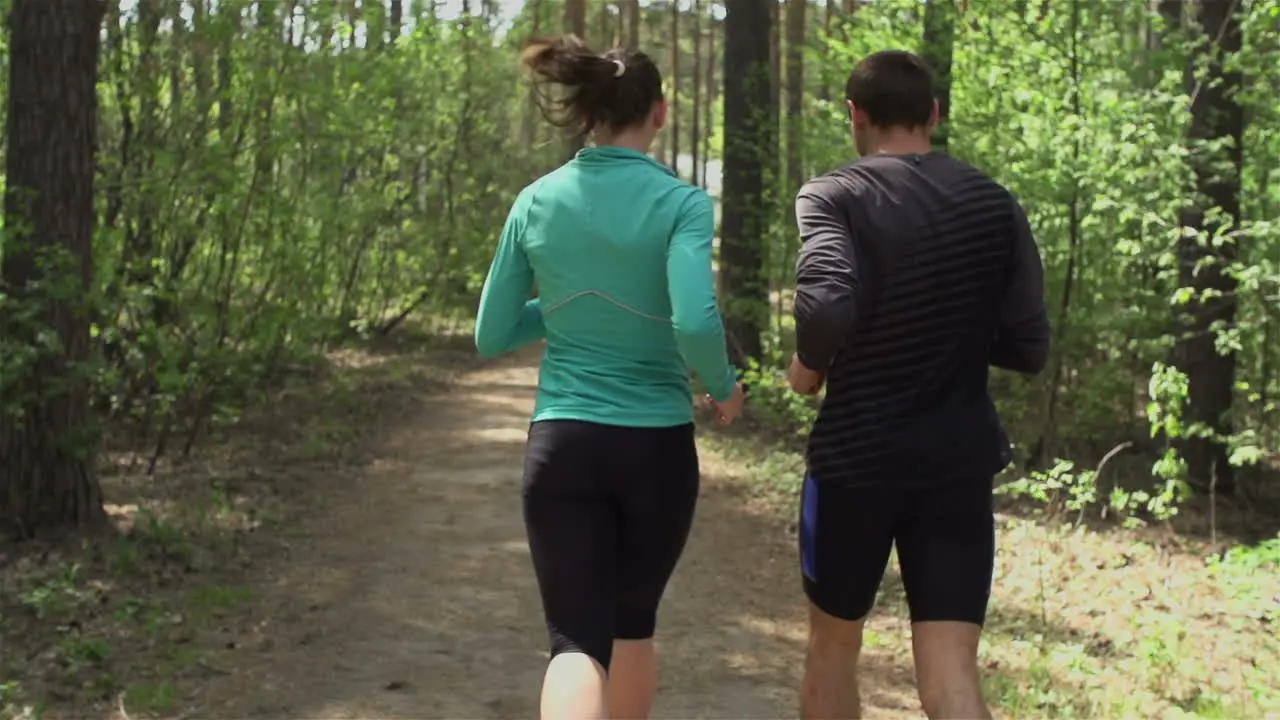 Sporty Couple Running Through The Forest