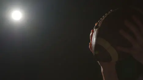 Close Up Studio Shot Of American Football Player Throwing And Catching Ball 