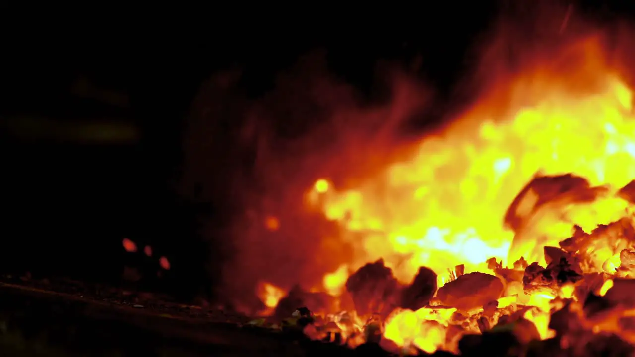 Blacksmith heating metal rod in fire 4k