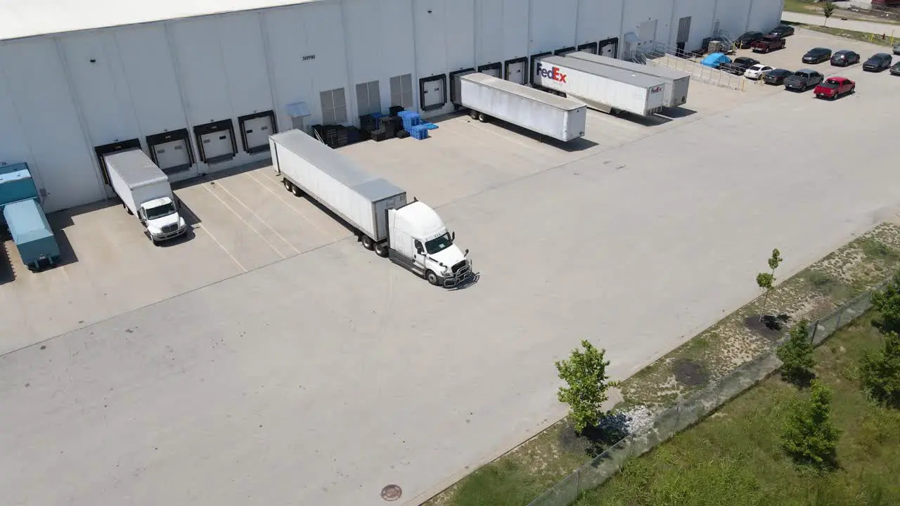 Drone shot of truck backing into logistics and shipping hub