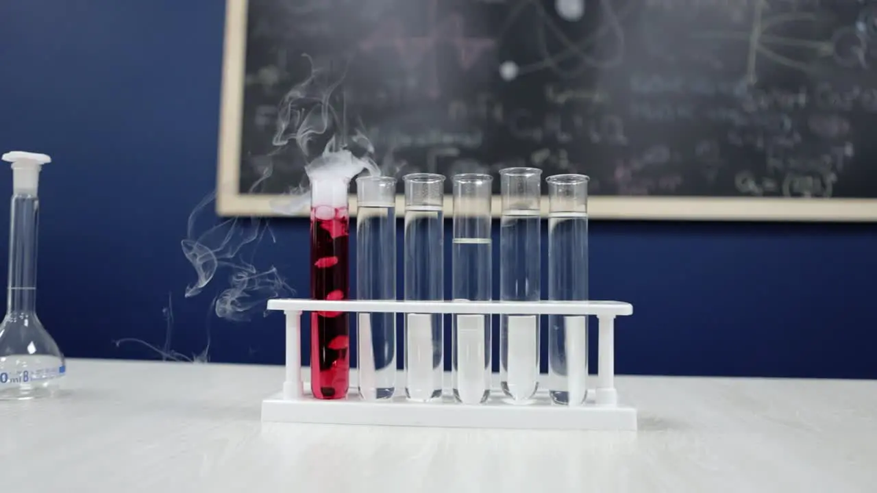 Test tubes stand tall as one emits white smoke from red liquid a mesmerizing chemical reaction in progress