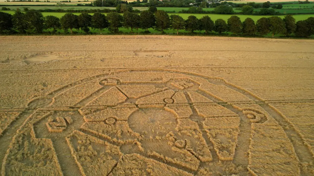 Crop circle Fortnite molecular geometry pattern aerial view on Wiltshire sunset wheat field countryside rising fast pull away