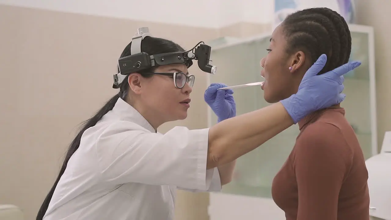 Female Doctor Does A Medical Check Up In A Patient's Mouth A Young Girl 1