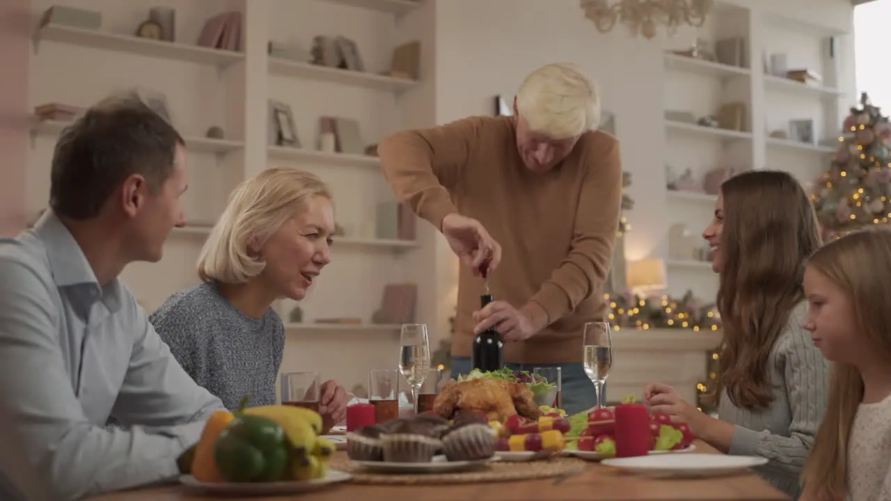 Grandpa Uncorks A Bottle Of Wine For A Toast