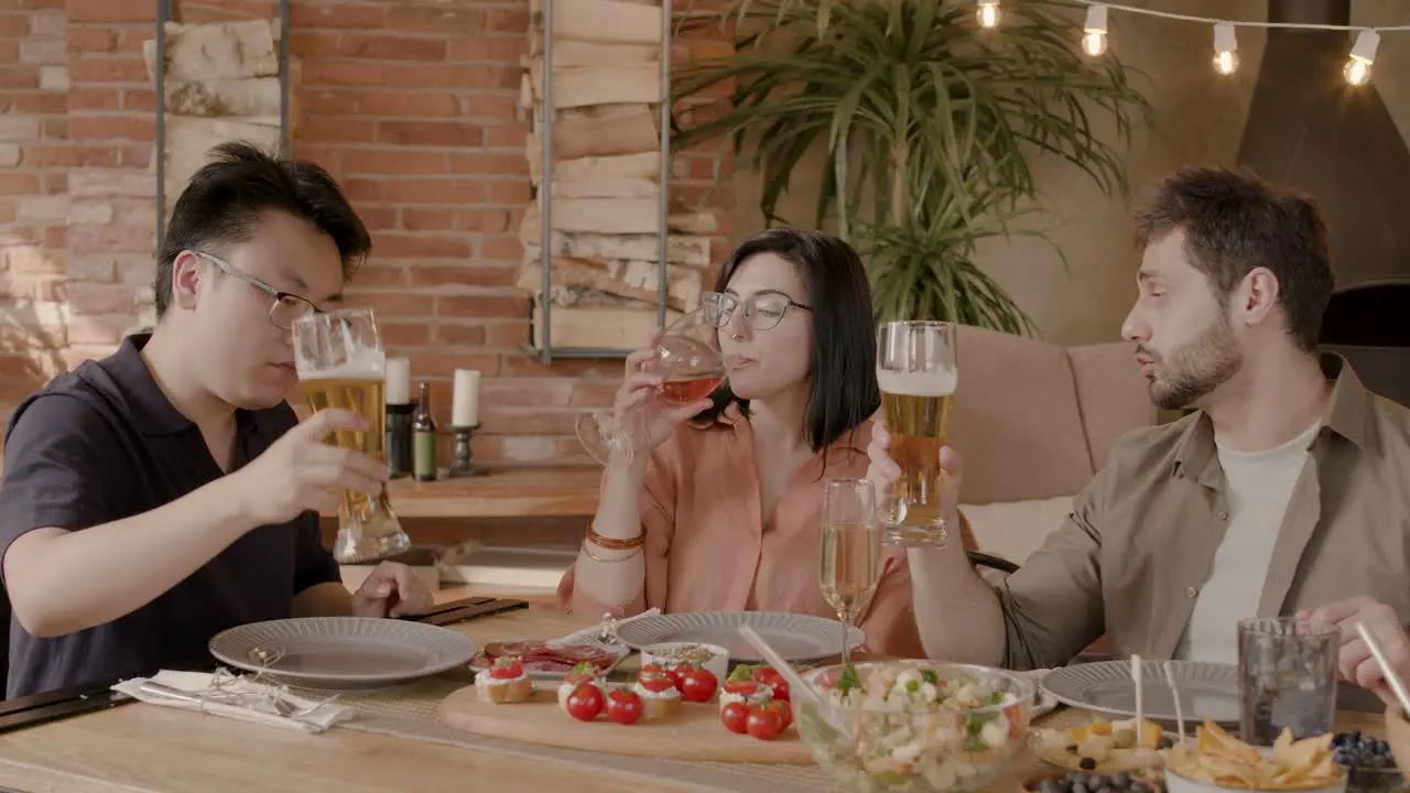 A Group Of Three Friends Toast With Their Glasses At A Dinner Party 1